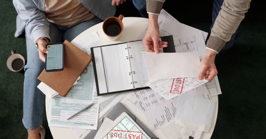 Couple checking bills and using calculator