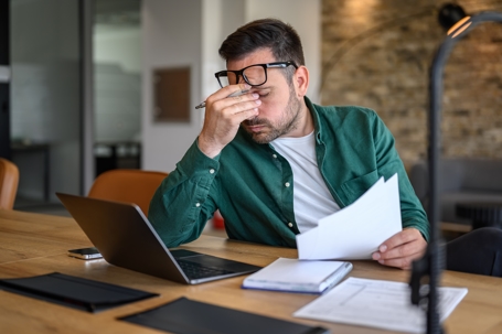 stressed man looking over paperwork